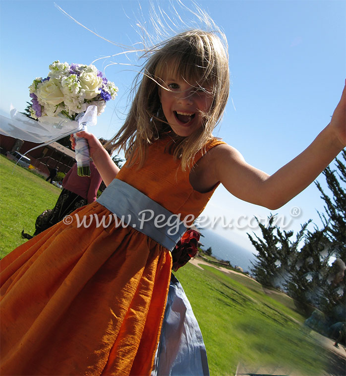 Powder blue and tangerine silk flower girl dresses at beach wedding