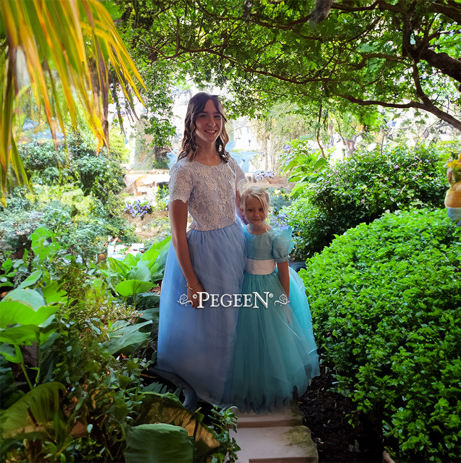 Sister coordinating flower girl dresses in blue and aqua